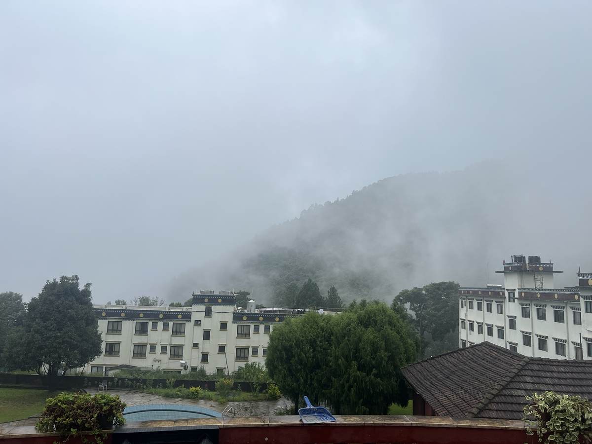 Clouds rolling over the forested hill above the pool