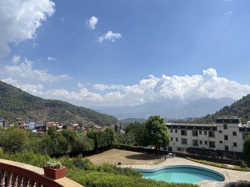 Outdoor pool with hills and clouds